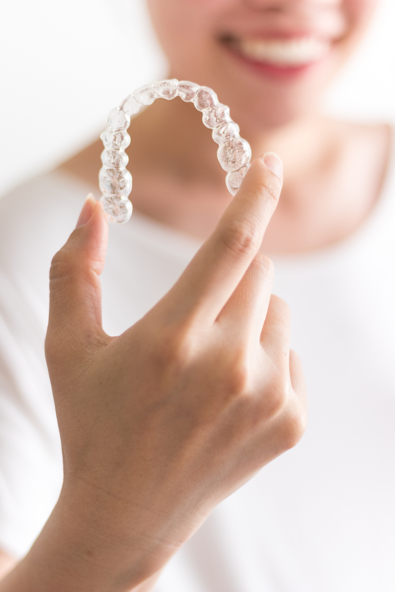 woman holding clear aligner trays