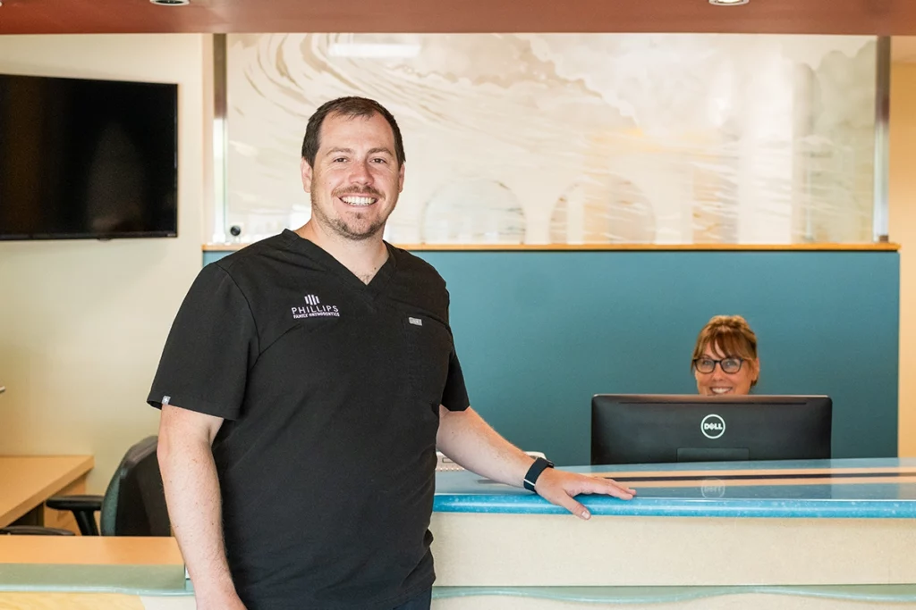 Dr. Joseph Phillips welcoming a patient into Phillips Family Orthodontics office, where we address common problems in orthodontics with care and expertise.