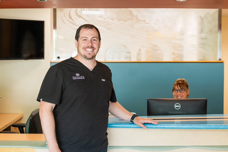 Dr. Joseph Phillips welcoming a patient into Phillips Family Orthodontics office, where we address common problems in orthodontics with care and expertise.