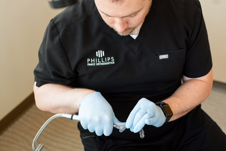 dr phillips adjusts an appliance to support a patient with ideal jaw alignment from good tongue posture and myofunctional therapy