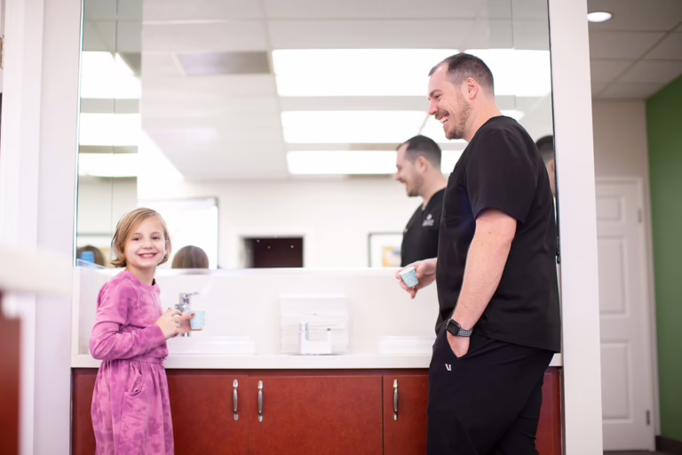 Orthodontist and child smiling and laughing during Invisalign for kids consultation