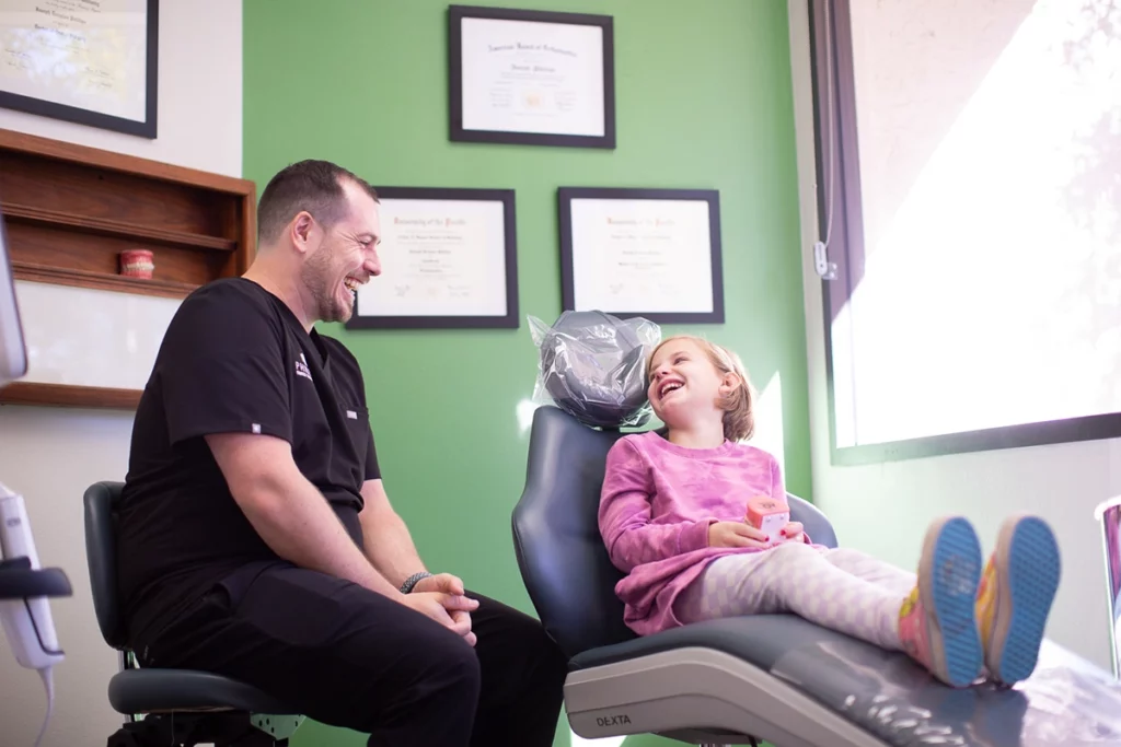 Dr. Joseph Phillips, an orthodontist in Mira Mesa, stands in his Mira Mesa Office and Shares A Laugh During a Consultation