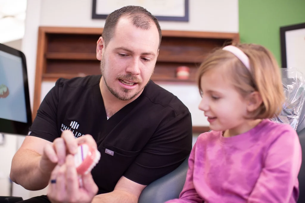 Dr. Joseph Phillips explaining a palatal expander to a young patient at Phillips Family Orthodontics