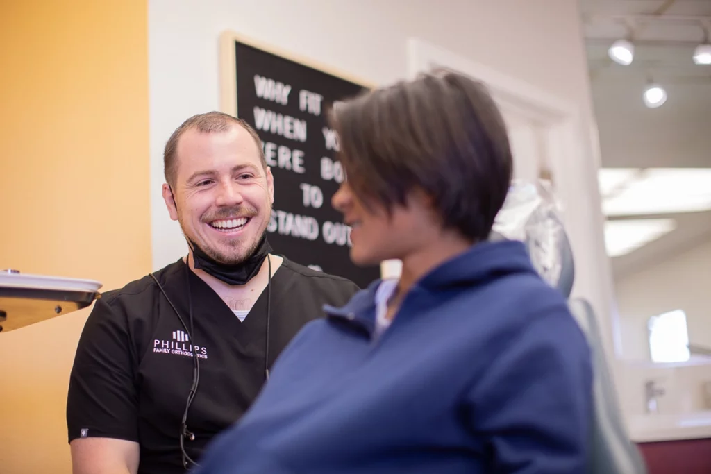 Dr. Phillips laughing with a teen patient while discussing braces for teens treatment at Phillips Family Orthodontics.