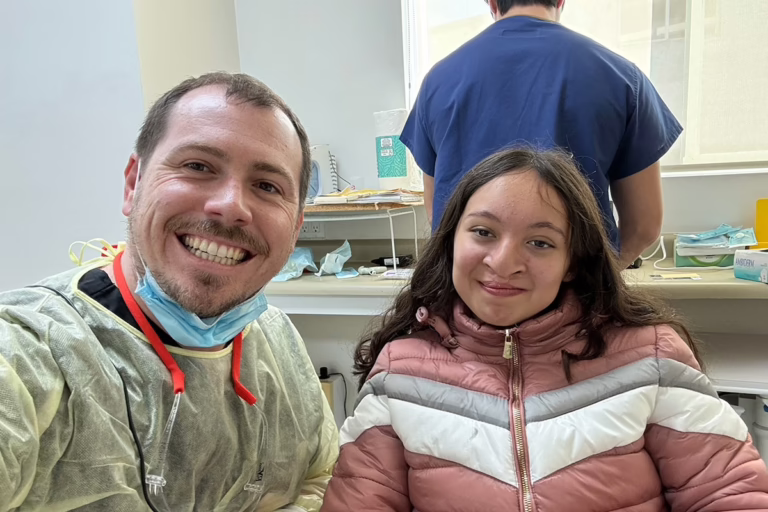 Dr. Phillips smiling with a cleft palate patient receiving free orthodontic treatment at Phillips Family Orthodontics