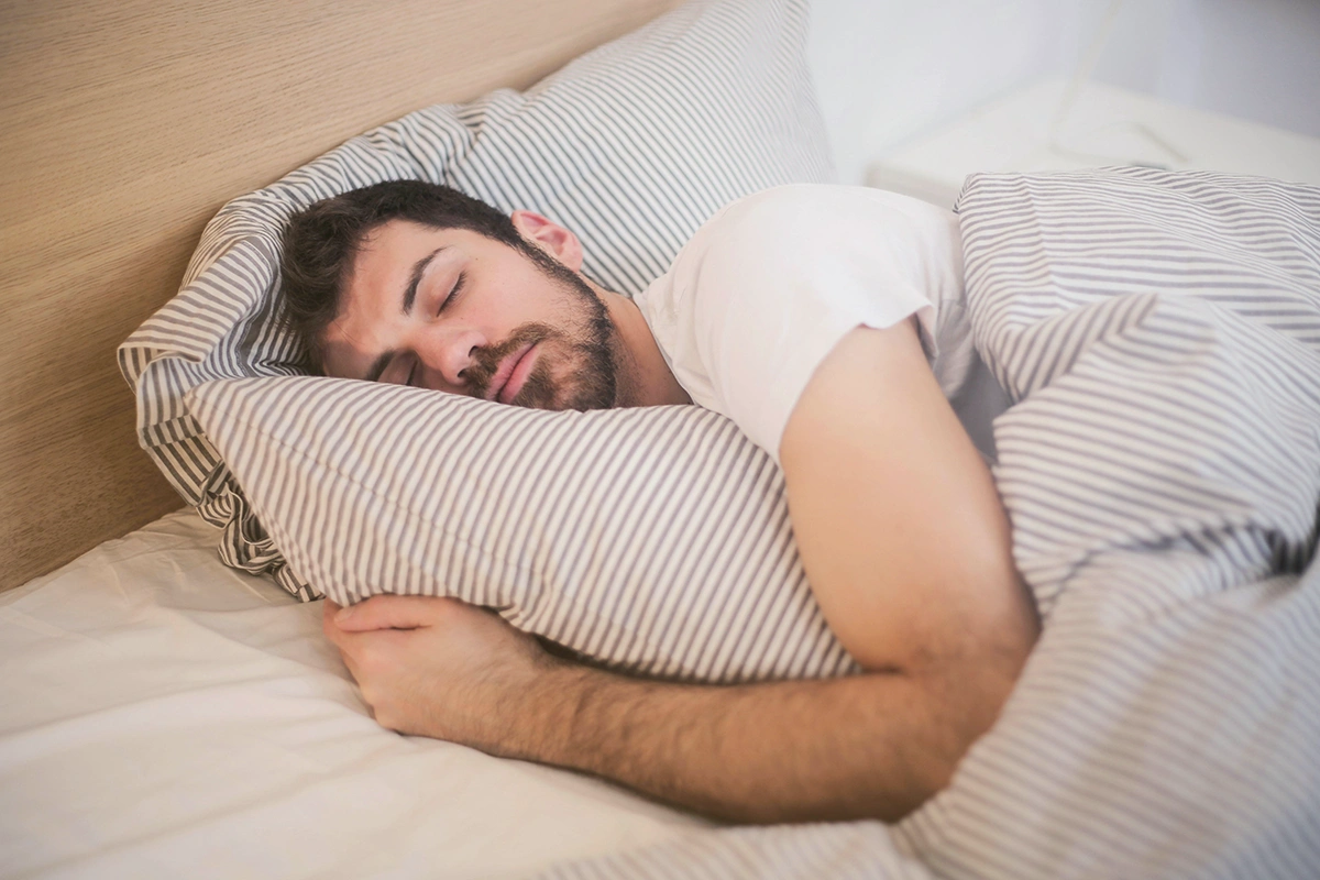 A man peacefully sleeping in bed, unaware of needed potential sleep apnea and UARS palatal expansion orthodontic treatment.