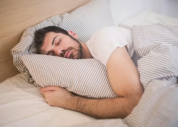 A man peacefully sleeping in bed, unaware of needed potential sleep apnea and UARS palatal expansion orthodontic treatment.